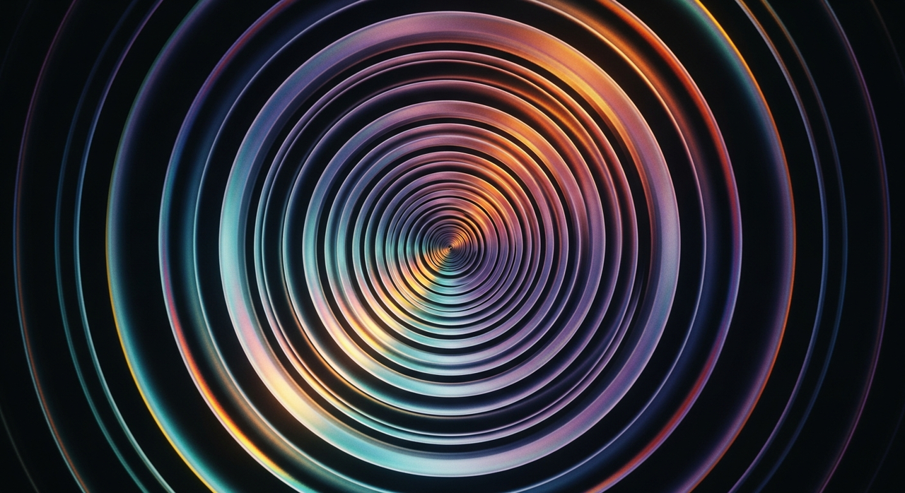 A series of iridescent concentric rings or spirals expanding outwards against a dark background.
