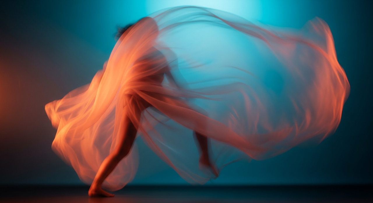 A piece of translucent fabric gracefully draped and flowing, against a soft, blurred background.